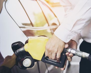 Man putting gasoline fuel into his car in a pump gas station