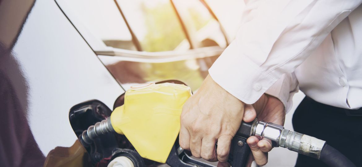 Man putting gasoline fuel into his car in a pump gas station