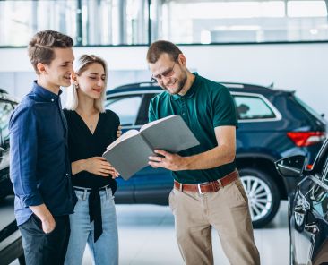 Young family buying a car in a car showroom